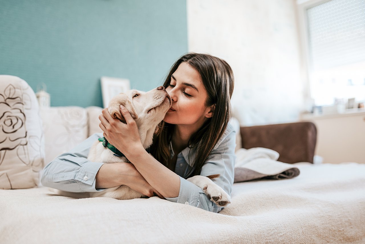 Passionate dog owner kissing her dog.